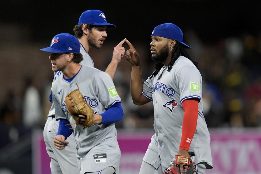 El lanzador relevista de los Azulejos de Toronto, Jordan Romano, arriba a la izquierda, celebra con su compañero de equipo, el primera base Vladimir Guerrero Jr., después de que los Azulejos derrotaron 5-2 a los Padres de San Diego en un juego de béisbol, el sábado 20 de abril de 2024, en San Diego. (AP Foto/Gregory Bull)