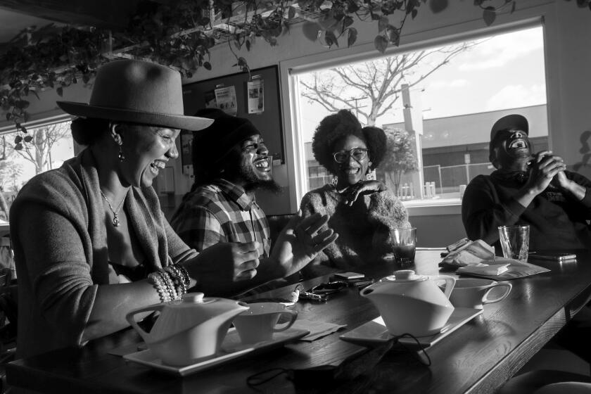 Long Beach, CA - March 05: A group of writers and artist Shelley Bruce, left, Micah Bournes, Keayva Mitchell and Antonio Cortez Appling share light moment during their meet at Wrigley Coffee on Saturday, March 5, 2022 in Long Beach, CA. (Irfan Khan / Los Angeles Times)