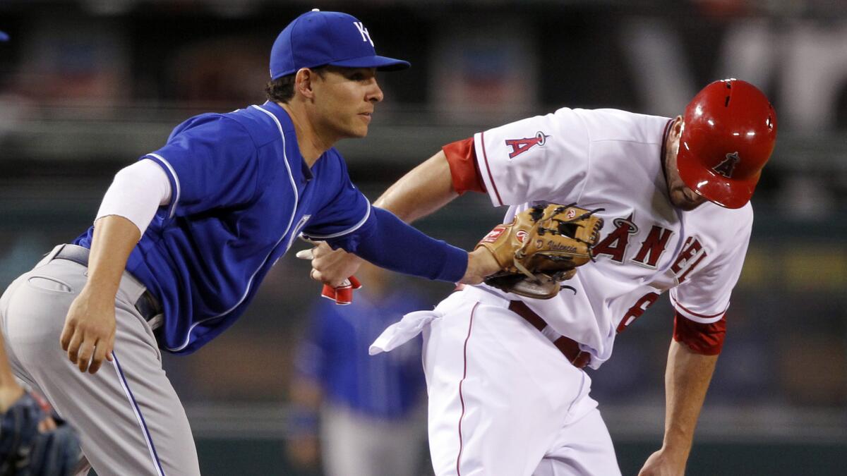 Kansas City Royals third baseman Danny Valencia, left, tags out Angels baserunner David Freese in a rundown between third and second base during the 10th inning of the Angels' 7-4 loss Saturday.