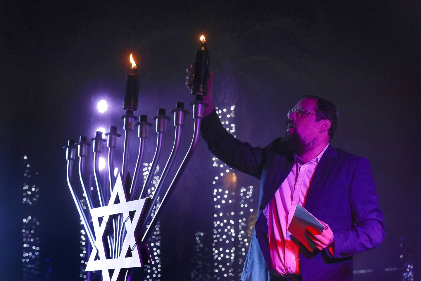 Rabbi Yossi Tiefenbrun of Chabad of Pacific Beach lights the menorah candle signifying the first night of Hanukkah on Nov. 28 at Liberty Station in Point Loma.