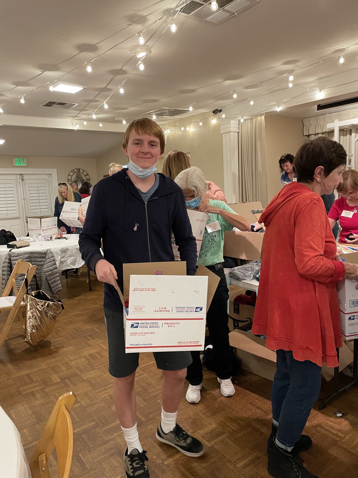 Colin Kavanaugh, a sophomore at The Bishop's School, holds a box he helped pack with items for women in the armed forces.