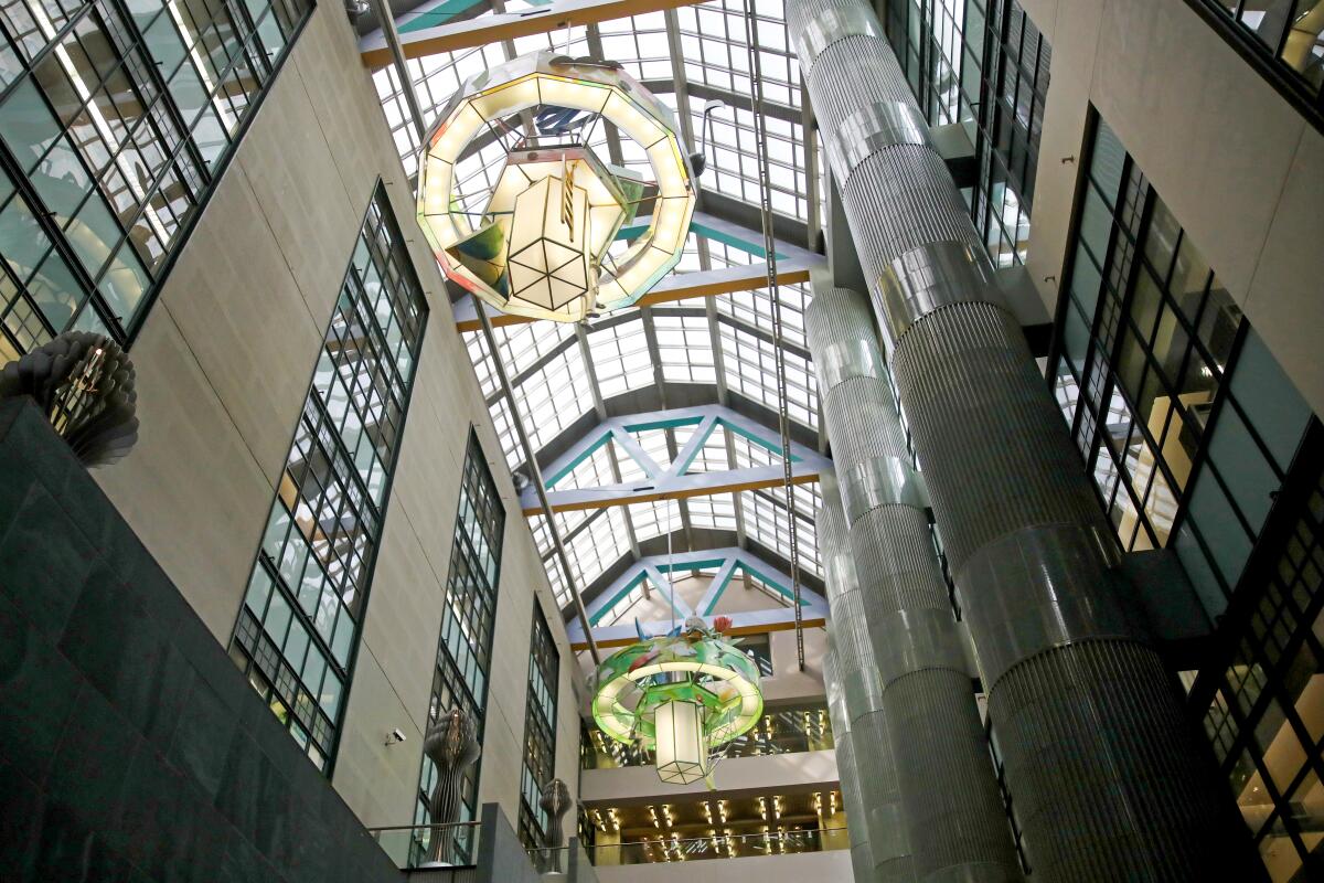 A glass-roofed atrium with chandeliers.