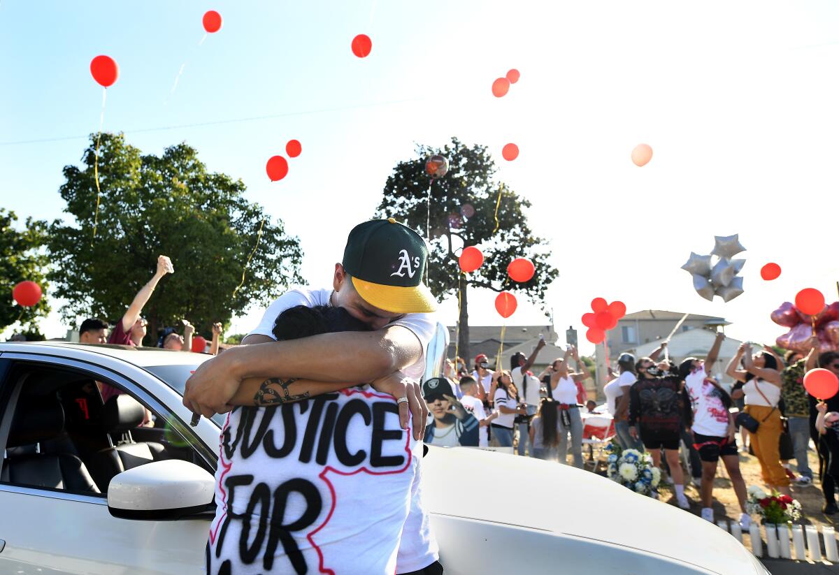 Leah Garcia, who lost her son, receives a hug during a vigil in Los Angeles.