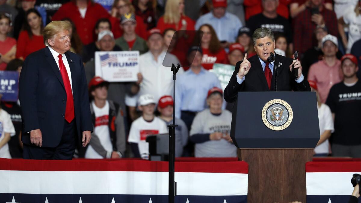 Television personality Sean Hannity speaks as President Trump listens during a campaign rally Tuesday in Cape Girardeau, Mo.
