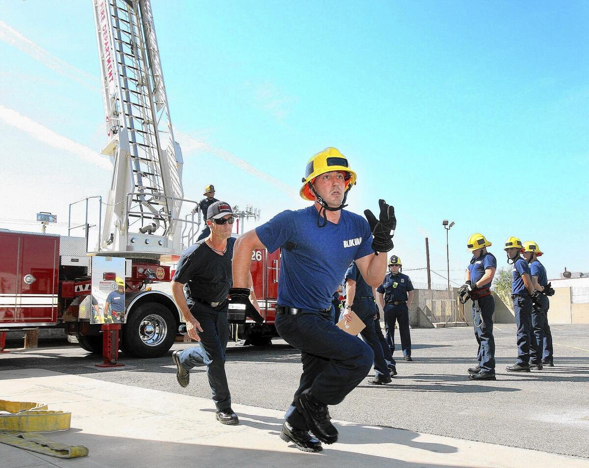 Fire recruit Blikian runs to the last task, a timed course. His trainer runs behind him on the first day of recruit training for the Glendale Fire Department at the training grounds in Glendale on Monday, March 17, 2014.