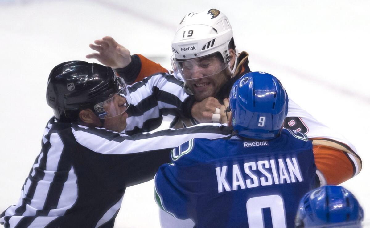 Linesman Jay Sharrers tries to break up a fight between Ducks forward Patrick Maroon and Vancouver forward Zack Kassian during Anaheim's 2-1 loss to the Canucks on March 9.