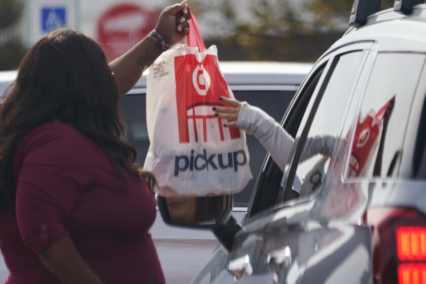 A Target employee hands a customer a curbside pickup purchase in Jackson, Miss., Thursday, Nov. 5, 2020. U.S. consumer prices were unchanged in October, the lowest reading in five months and an indication that the price spike seen this summer is beginning to fade as coronavirus cases start to increase. (AP Photo/Rogelio V. Solis)