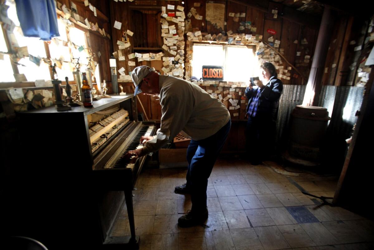 A man plays a piano in a bar.