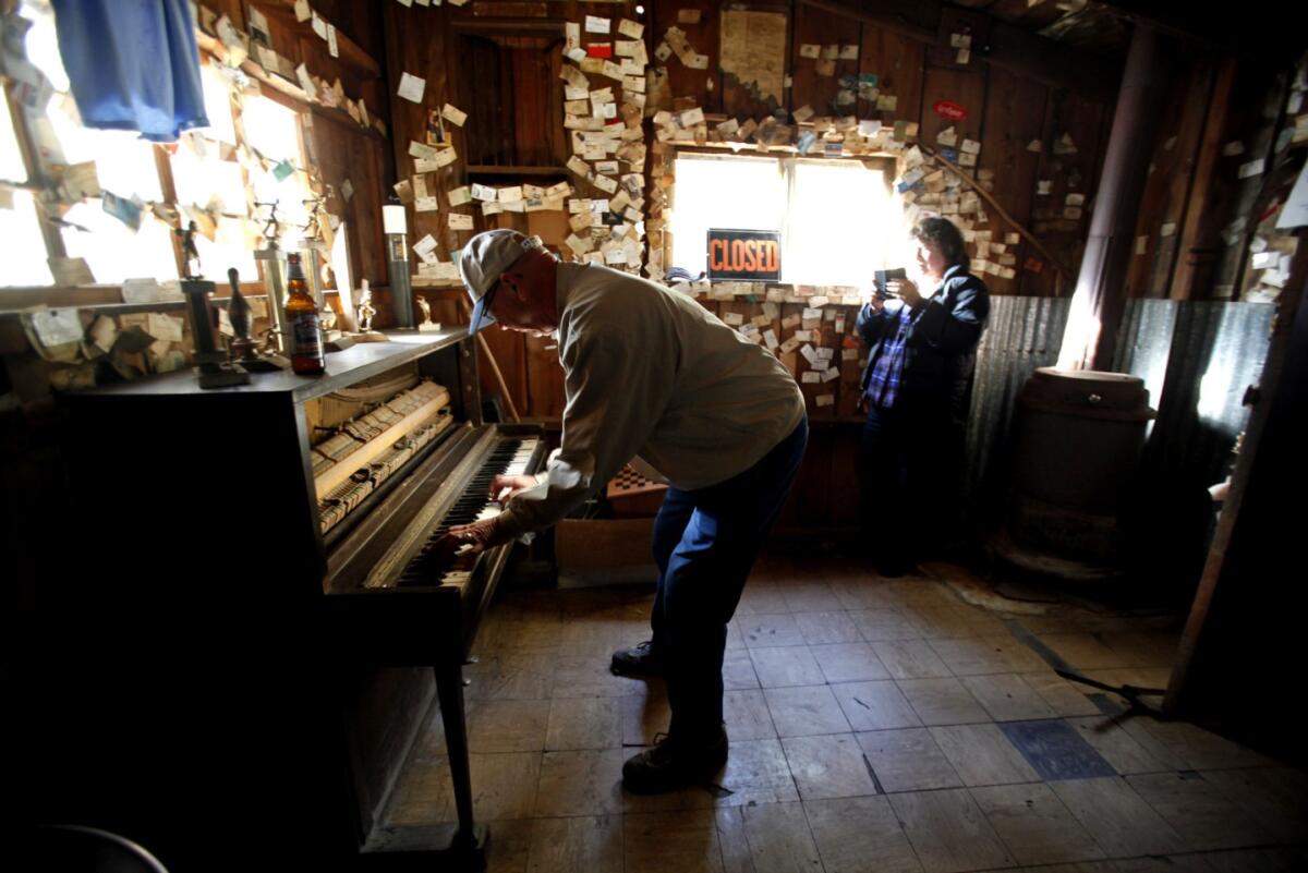 A man plays a piano in a bar. 