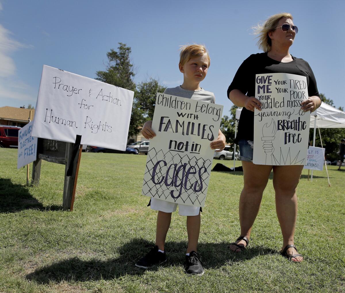 DODGE CITY, KAN.: Bennett Heeke, 5, and his mother, Sarah Doll Heeke, hold signs at a rally protesting U.S. immigration policies.