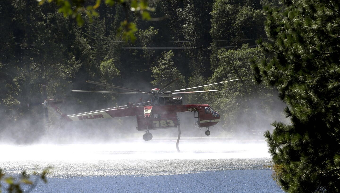 A helicopter refills its tanks with water to battle the King fire near Pollock Pines, Calif., on Sept. 15.