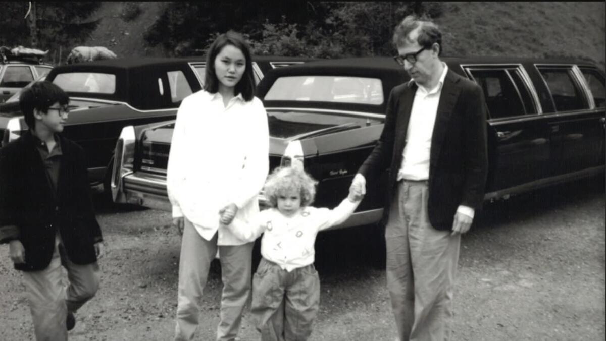 Dylan Farrow, as a child, holds the hands of Soon-Yi Previn and Woody Allen, alongside Moses Farrow.