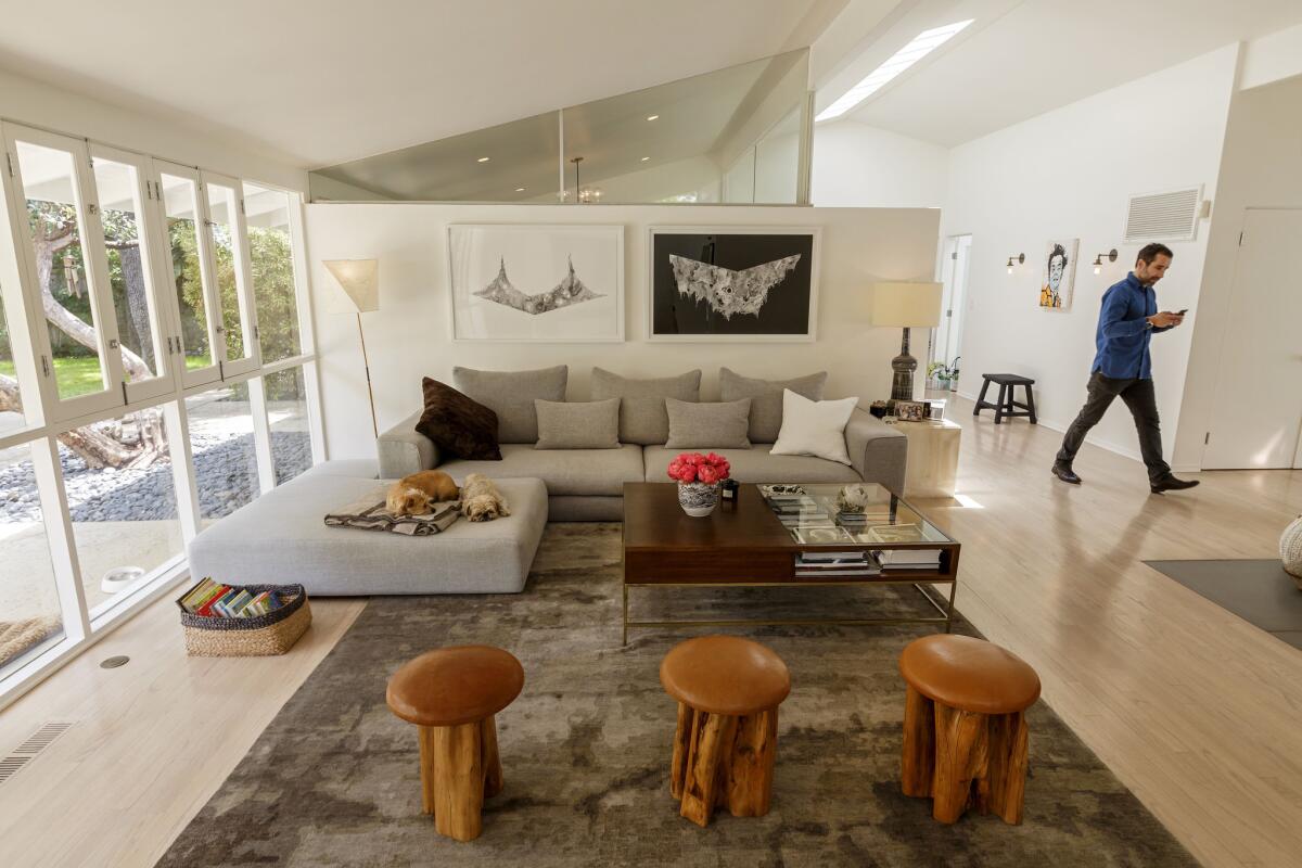 In the living room, clerestory windows atop partial walls add to the home’s open and airy feel. The window separates the living room and third bedroom which the couple use as a shared office space.