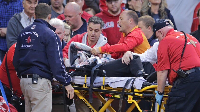Boston Red Sox fan Tonya Carpenter is taken away on a stretcher after getting hit in the head with a broken bat during a game against the Oakland Athletics at Fenway Park on June 5.