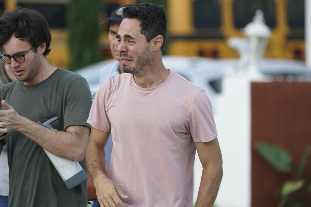 A man reacts as he waits for information after a partial building collapse in Surfside, Fla.