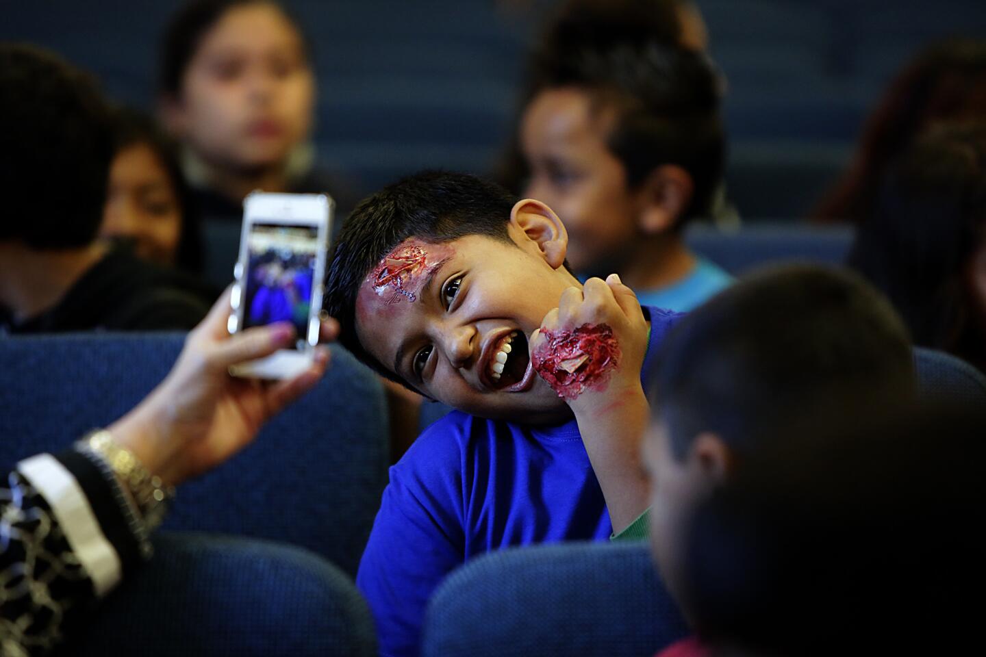 Leobely Hernandez, 11, has his picture taken in character as an earthquake victim, complete with fake gory injuries, before the Great California ShakeOut, a quake safety and preparedness drill, got underway at Rosemont Avenue Elementary School in Echo Park.