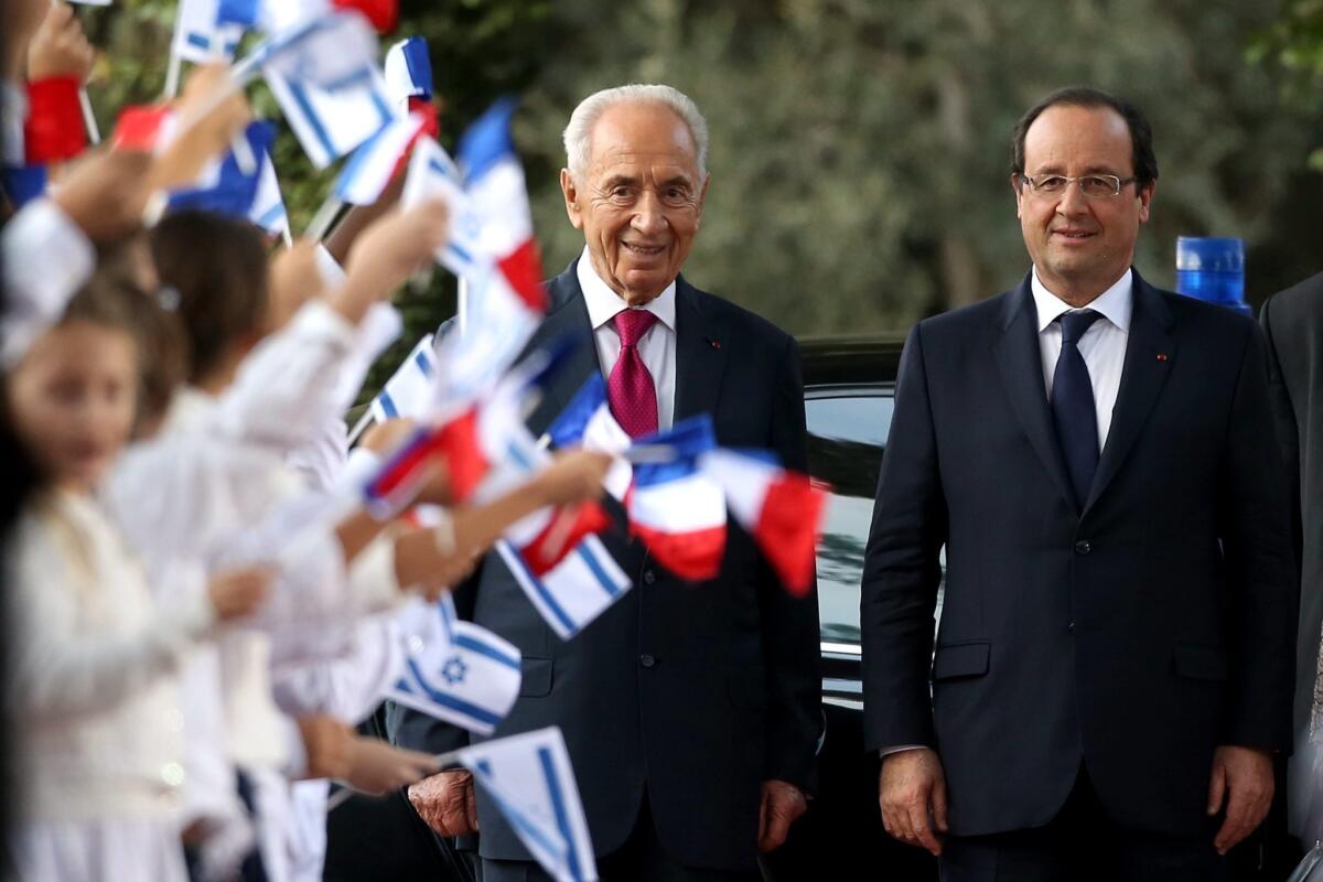 French President Francois Hollande (right) and Israeli President Shimon Peres are shown during a welcome ceremony Sunday at the Israeli president's residence in Jerusalem.