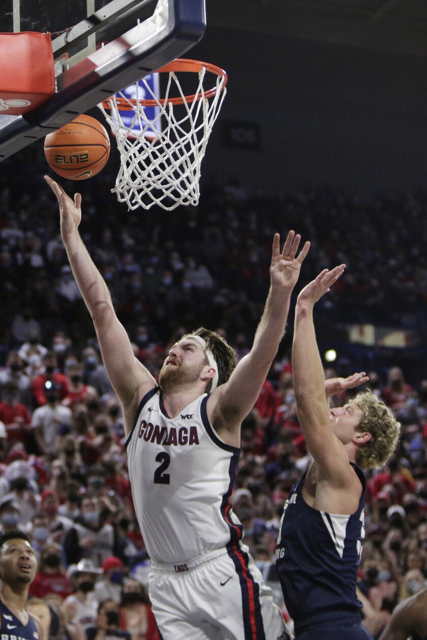 Gonzaga forward Drew Timme, left, shoots in front of BYU forward Caleb Lohner during the first half of an NCAA college basketball game, Thursday, Jan. 13, 2022, in Spokane, Wash. (AP Photo/Young Kwak)