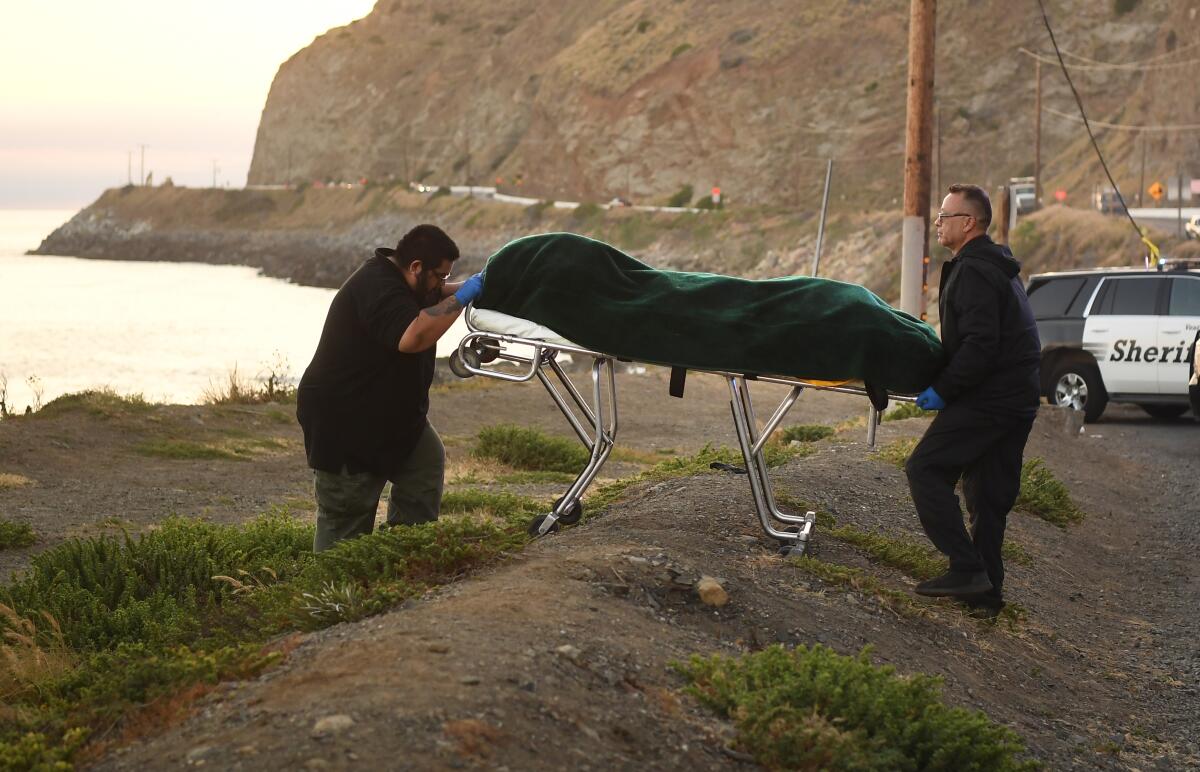 One of three drowning victims is carried away by Ventura County coroner's officials along Pacific Coast Highway