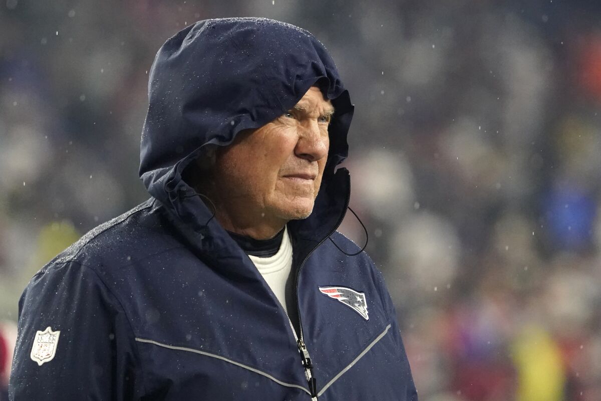 New England Patriots head coach Bill Belichick walks on the field in the rain prior to an NFL football game between the New England Patriots and Tampa Bay Buccaneers, Sunday, Oct. 3, 2021, in Foxborough, Mass. (AP Photo/Elise Amendola)
