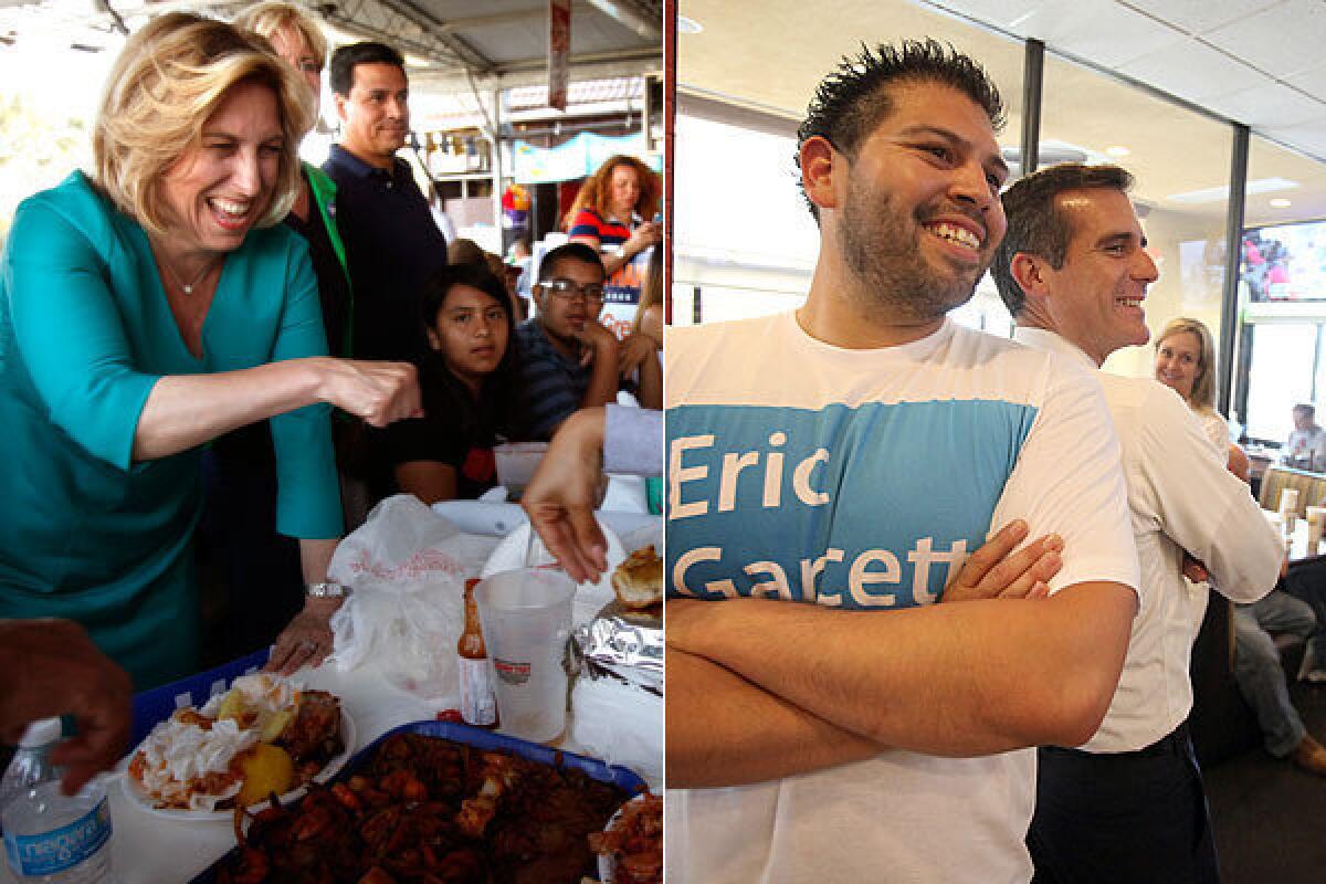 Mayoral candidate Wendy Greuel goes in for a fist bump at the Port O' Call in San Pedro. Rival Eric Garcetti poses with volunteer Richard Granados at Straw Hat Pizza in Chatsworth.