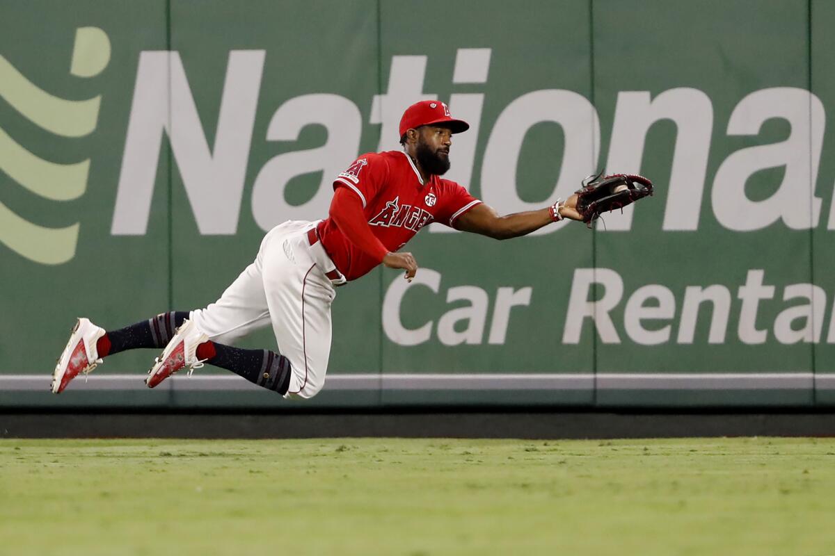 Angels' Brian Goodwin leaps to catch a line drive against the Oakland Athletics during the sixth inning at Angel Stadium on Sept. 25, 2019.