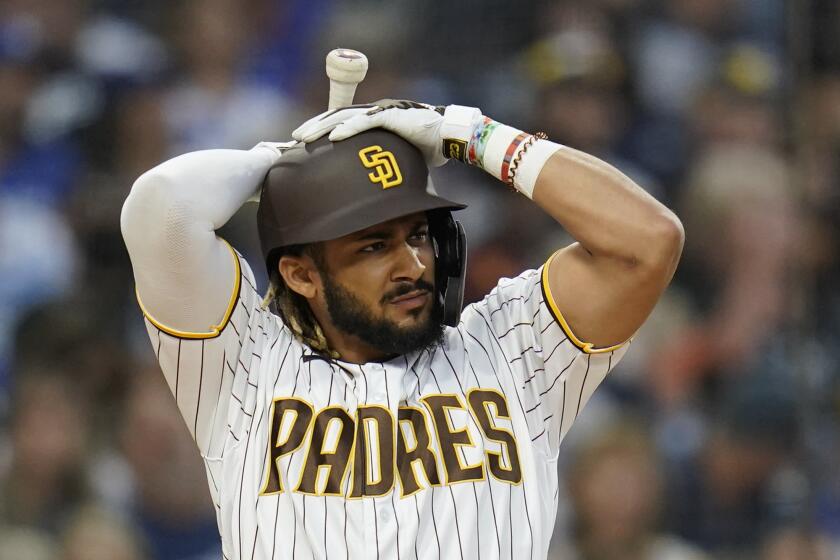 San Diego Padres' Fernando Tatis Jr. adjusts his helmet before striking out during the third inning of the team's baseball game against the Los Angeles Dodgers, Thursday, Aug. 26, 2021, in San Diego. (AP Photo/Gregory Bull)
