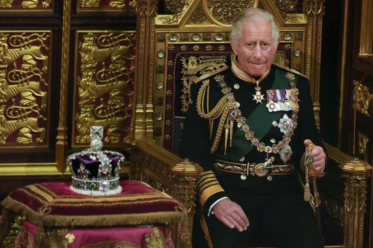 ARCHIVO - El príncipe Carlos sentado junto a la corona de la reina durante la apertura