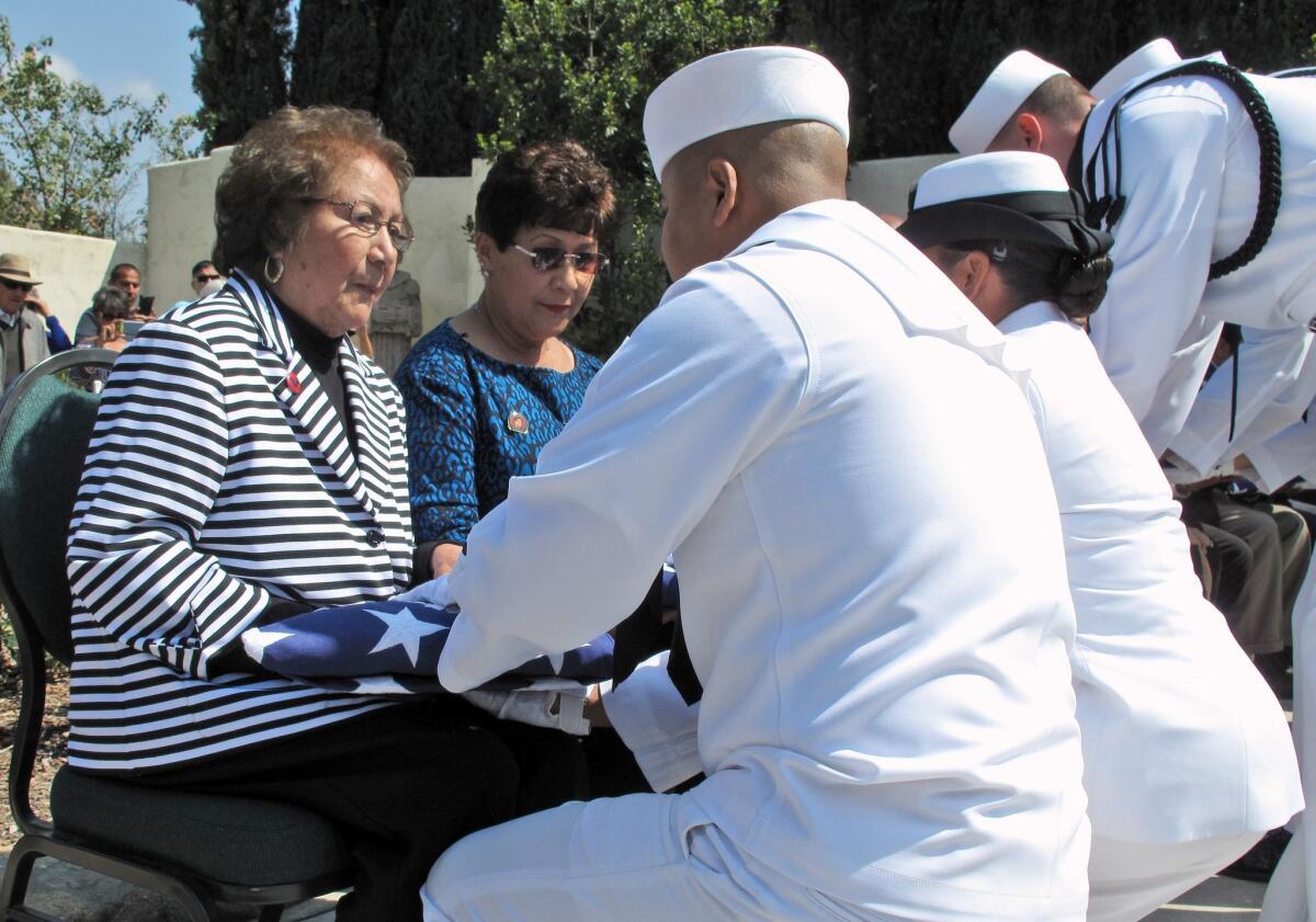 Helen Chavez, the widow of Cesar Chavez, receives a flag from the U.S. Navy, honoring her husband's military service during a ceremony in Keene, Calif.