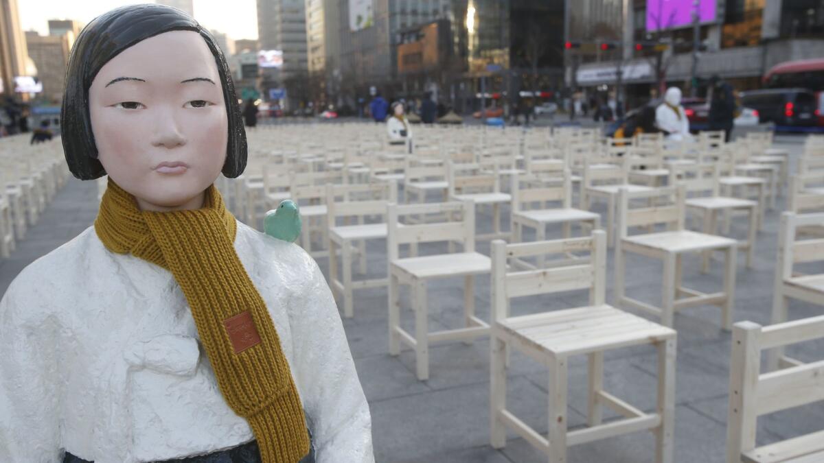 Statues symbolizing "comfort women" stand at Gwanghwamun Square in front of the Japanese Embassy in Seoul as part of a performance called "A Promise Inscribed on an Empty Chair" on Wednesday.