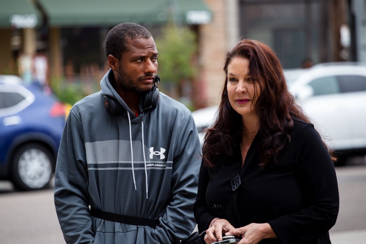 Jesse Evans and attorney Marlea Dell’Anno walk to a news conference in La Jolla on May 18.