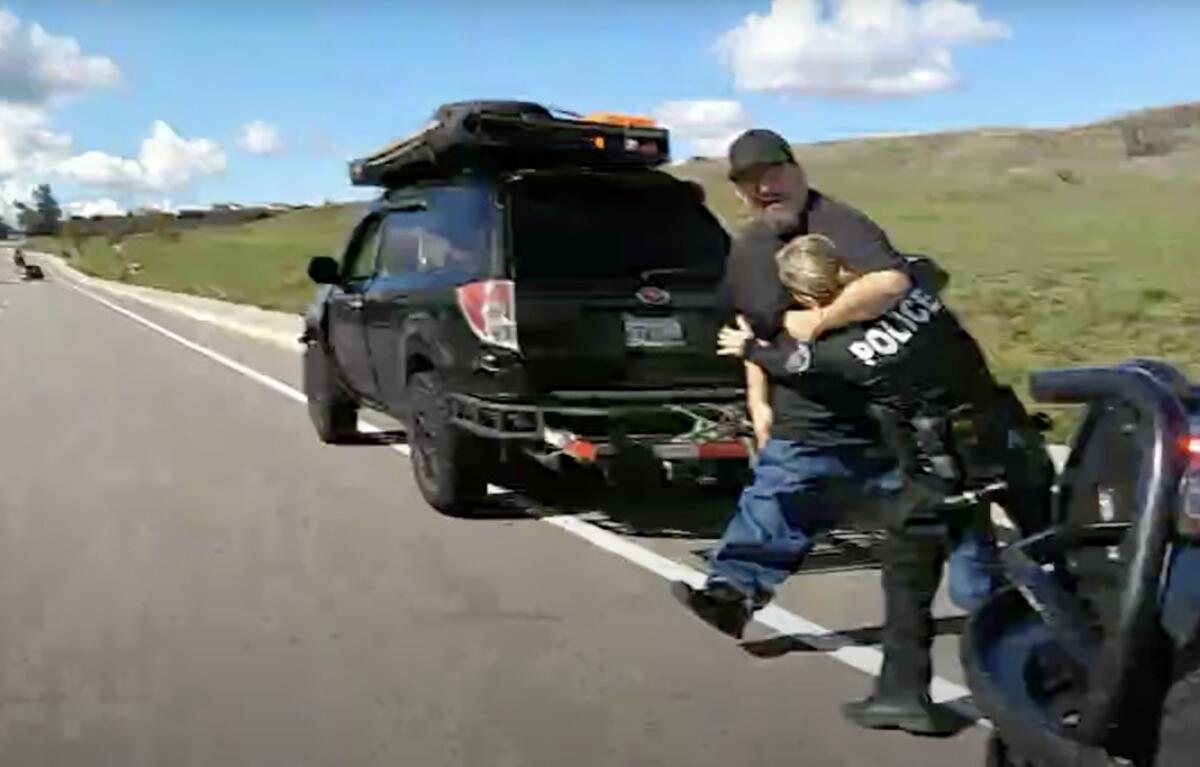 A video still, showing a man putting a police officer in a headlock.