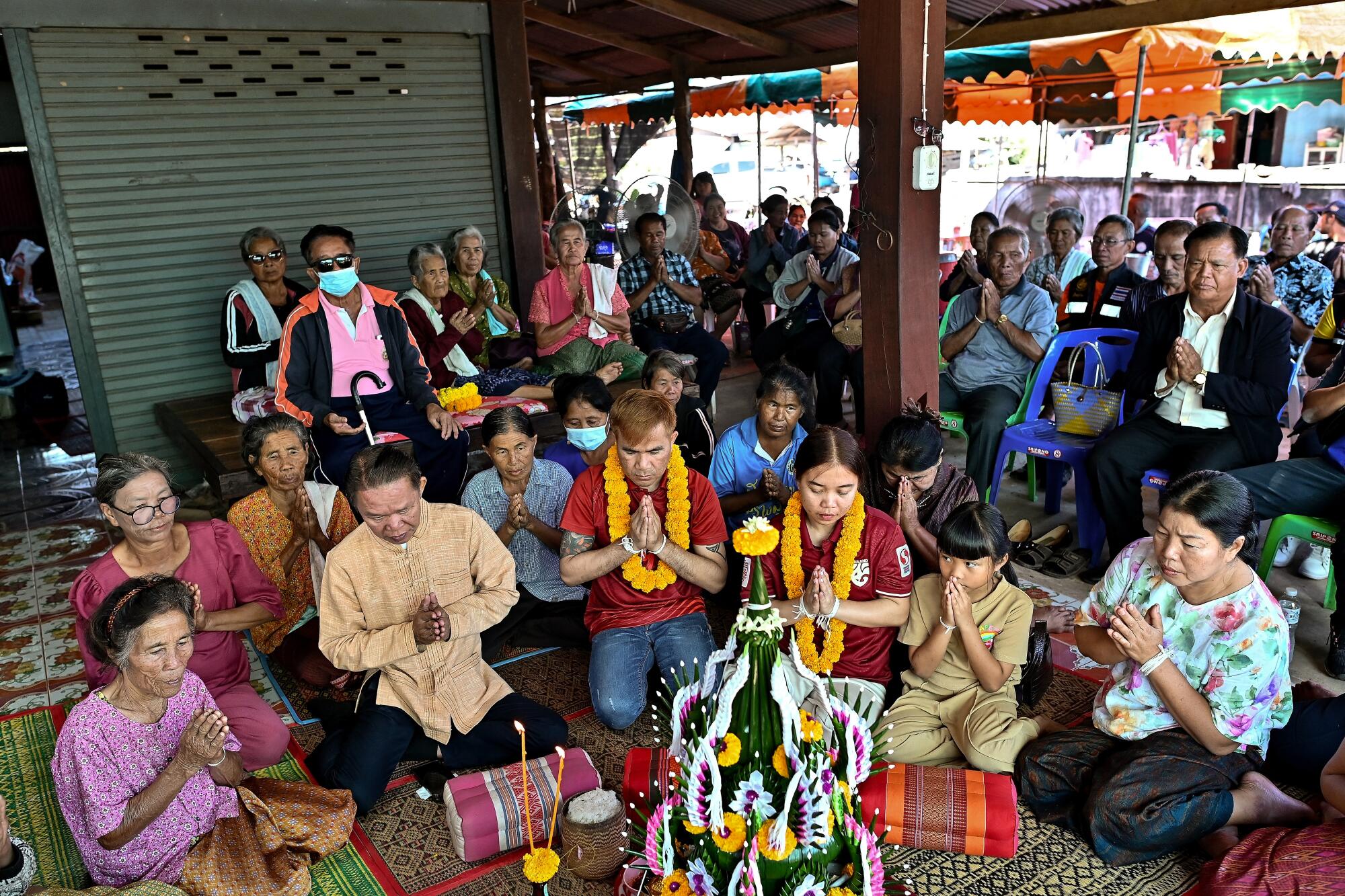 People take part in a welcoming ceremony at a house in northeastern Thailand.