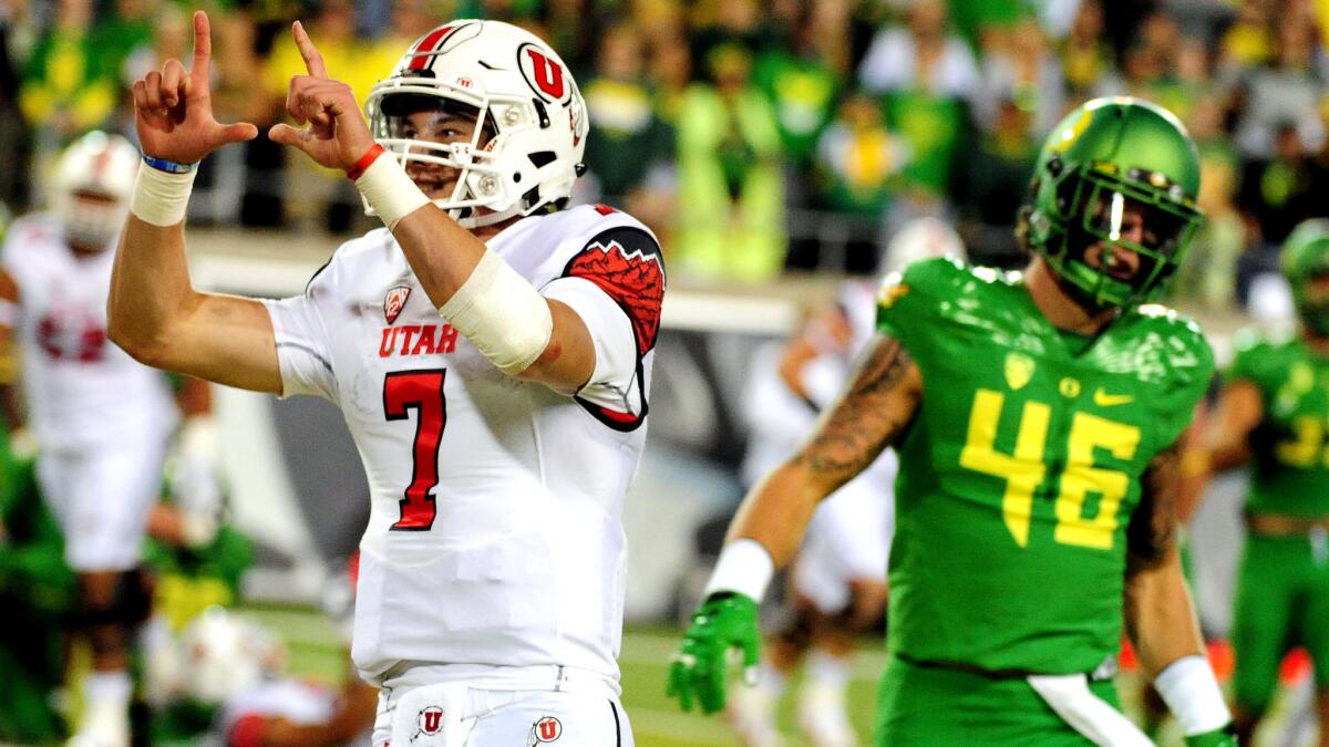 Utah quarterback Travis Wilson celebrates after beating linebacker Danny Mattingly and the Oregon defense for a touchdown in the third quarter Saturday night at Autzen Stadium.