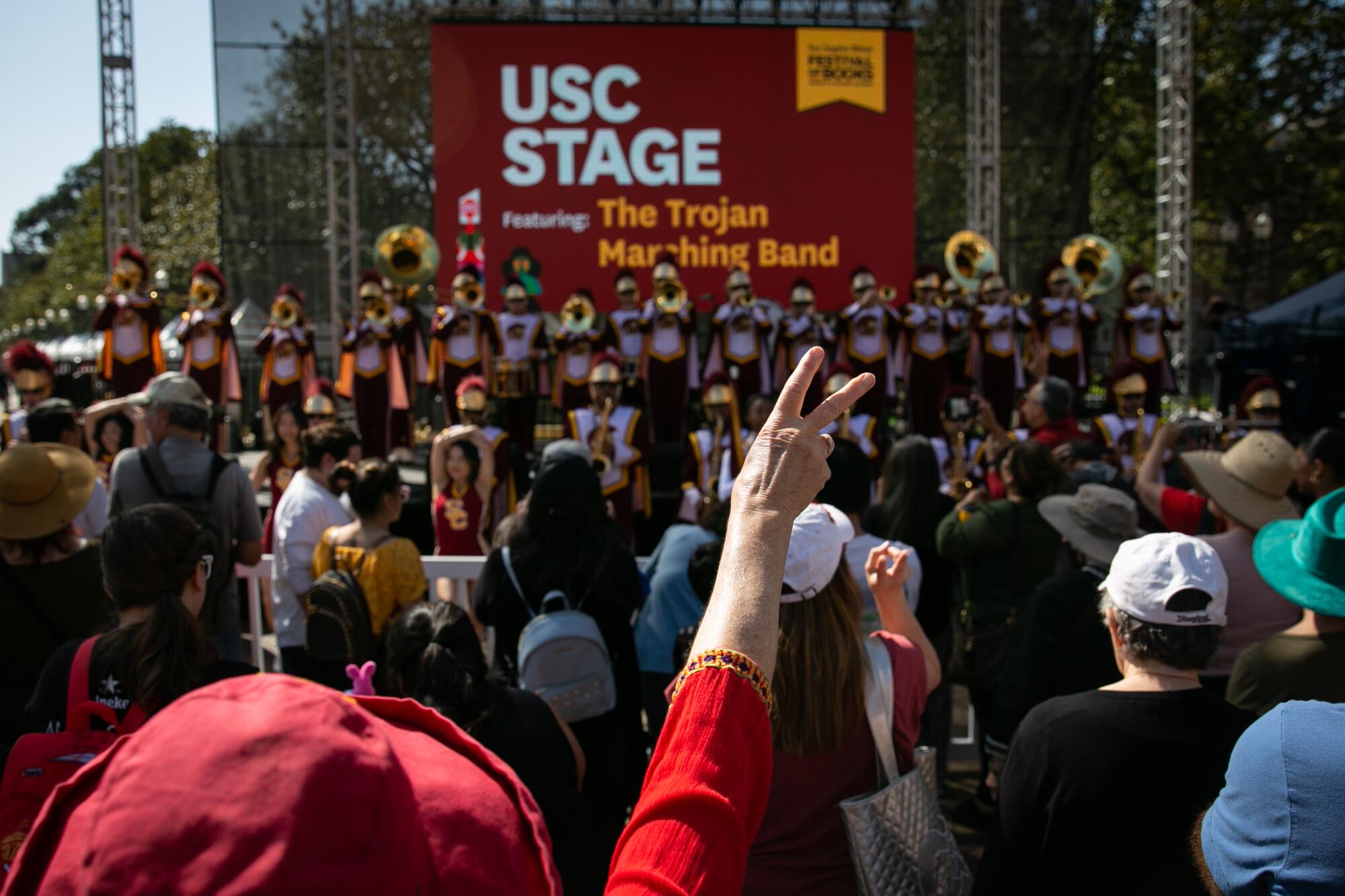 An attendee gestures while the USC Marching Band performs.