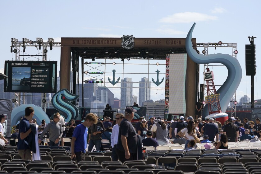 Fans take their seats on Wednesday near the stage in a Seattle park before the Seattle Kraken's NHL expansion draft event.
