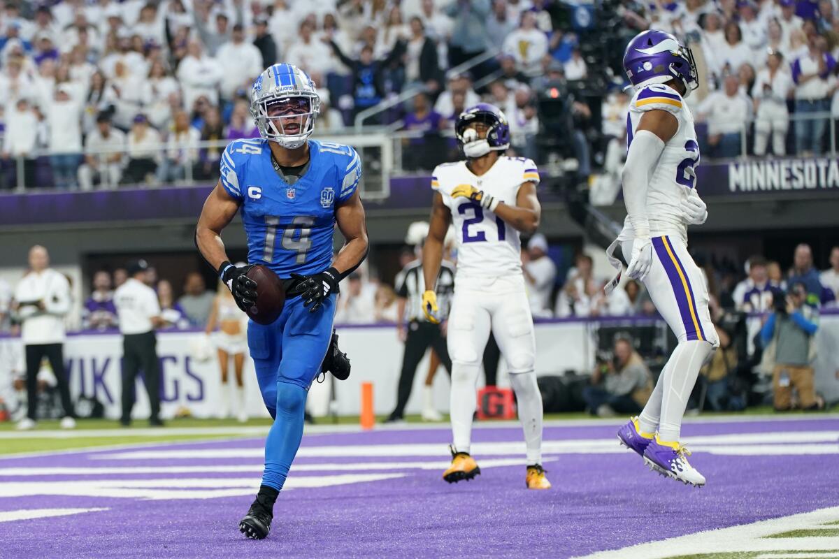 Lions wide receiver Amon-Ra St. Brown (14) celebrates after catching a one-yard touchdown pass against the Vikings on Sunday.
