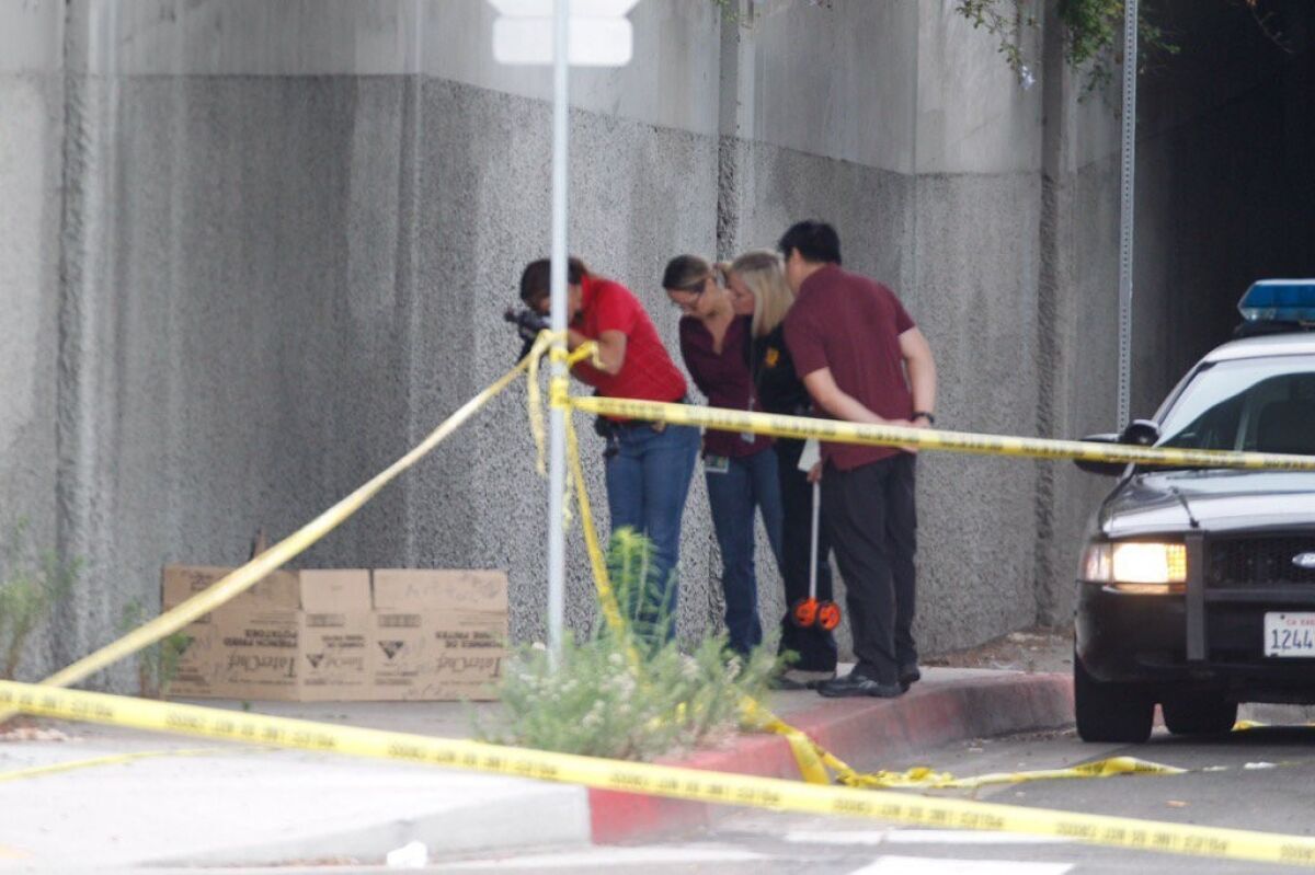 Police document the scene where a homeless man was attacked July 15 in downtown San Diego.