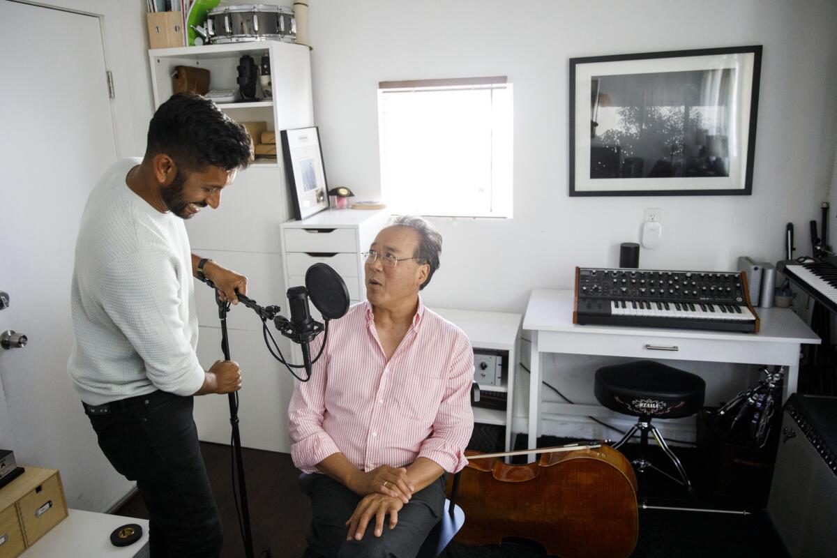 Hrishikesh Hirway, left, prepares to interview cellist Yo-Yo Ma in Hirway's home studio.
