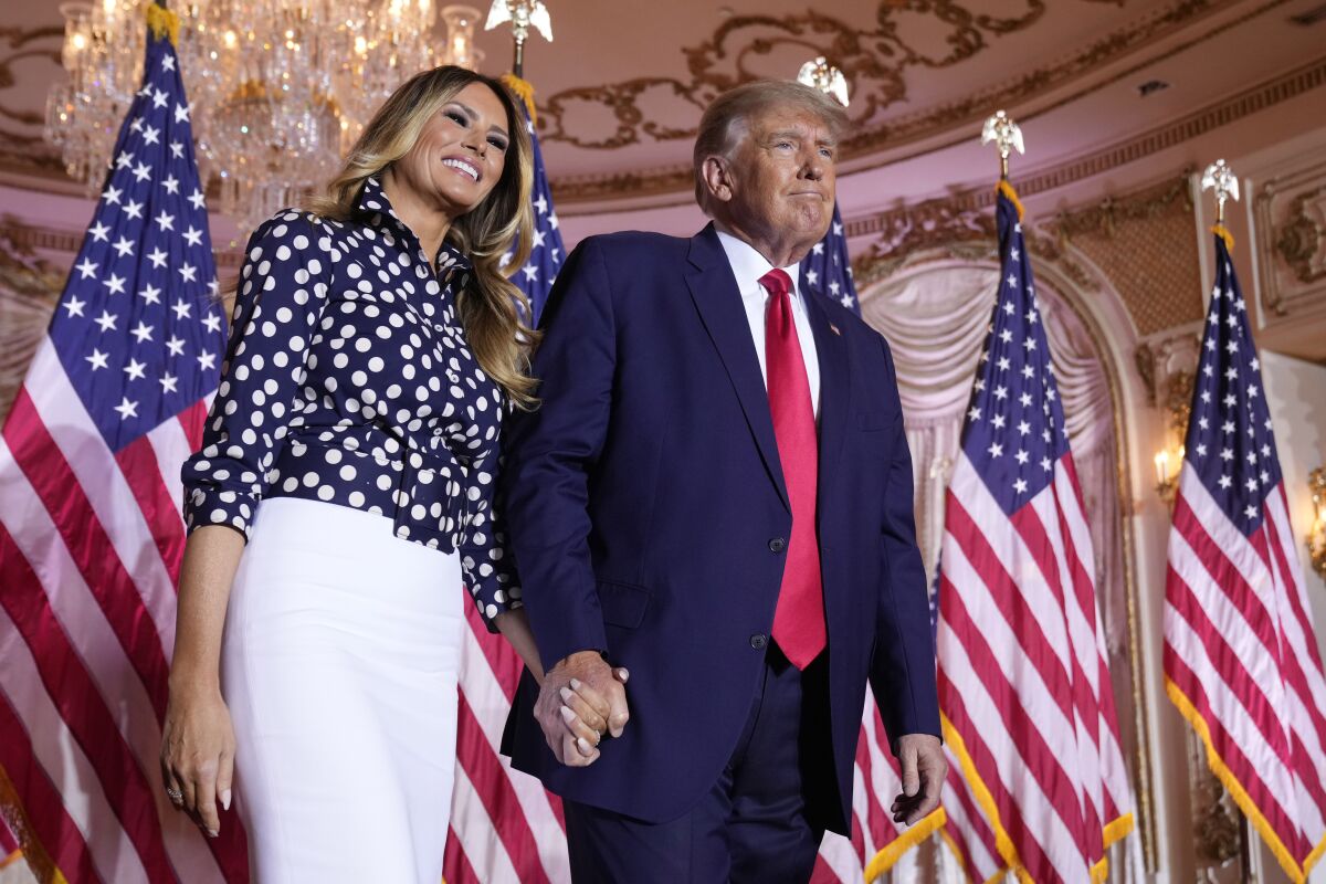 El expresidente Donald Trump permanece de pie sobre el escenario junto con la exprimera dama Melania Trump 