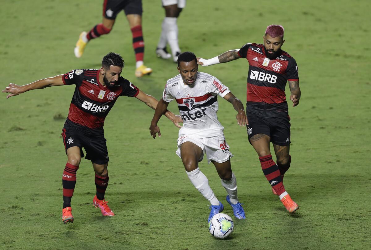 Welington (centro) de Sao Paulo avanza con el balón ante la marca de Gabriel Barbosa (derecha) 