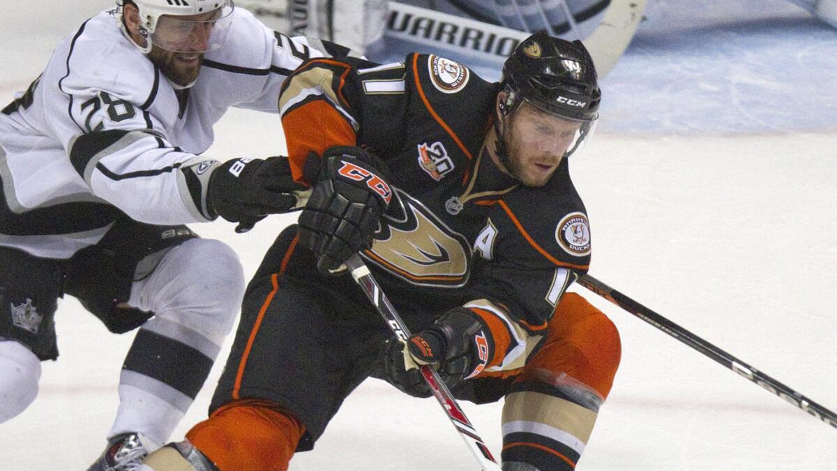Ducks forward Saku Koivu, right, controls the puck in front of Kings forward Jarret Stoll during the second period of the Ducks' 3-1 loss to the Kings in Game 2 of the Western Conference semifinals.