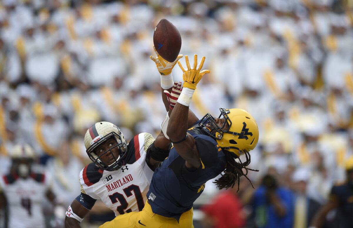 Maryland defensive back Alvin Hill, left, breaks up a pass intended for West Virginia wide receiver Kevin White during the Mountaineers' 40-37 victory on Saturday.