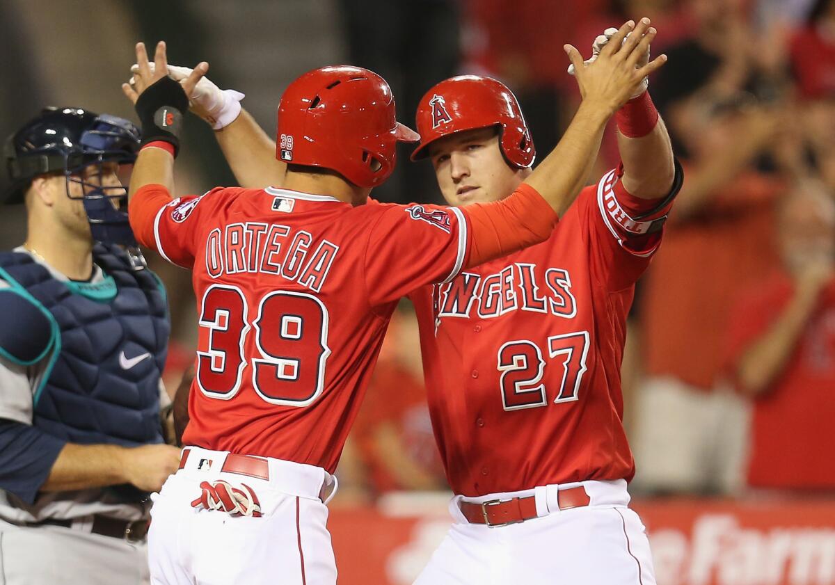Mike Trout celebrates with Rafael Ortega (39) after hitting a two-run home run against the Mariners during the sixth inning of a game at Angel Stadium on April 23.