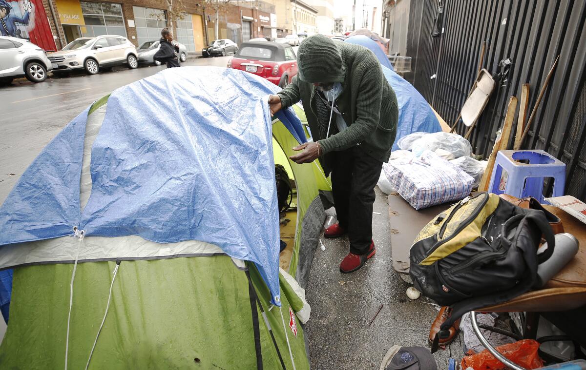 A man looks into his tent on L.A.'s skid row