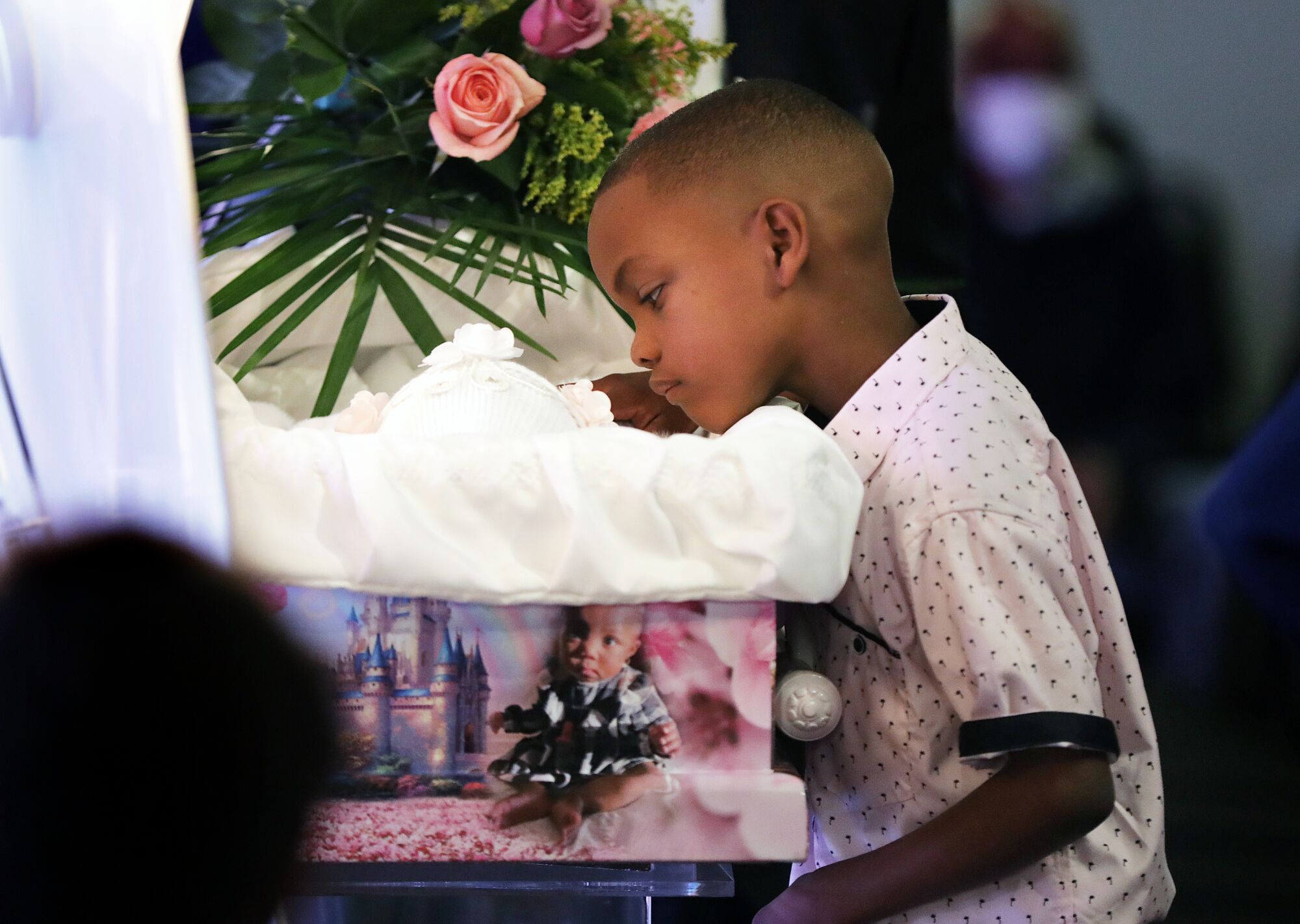 A boy looks into a casket.
