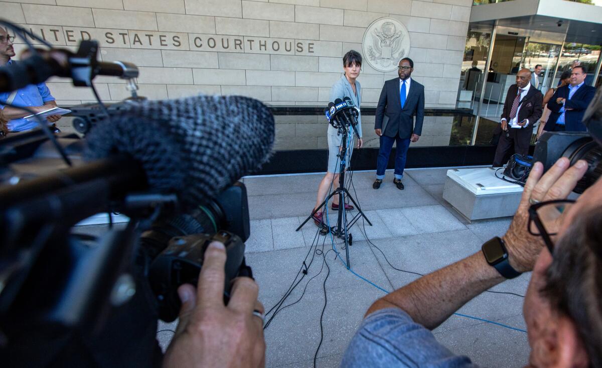 Attorney Galia Amram, left, and Sinclair Ridley-Thomas speak to the media outside a courthouse.