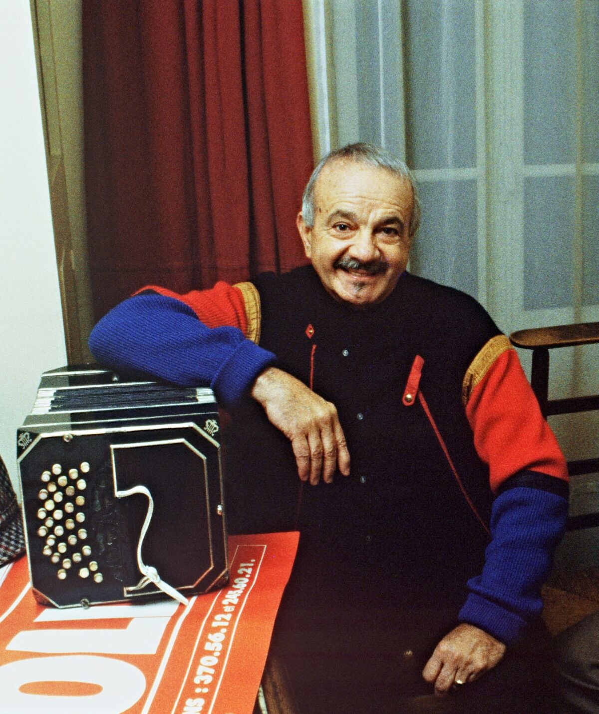 Astor Piazzola poses for a photo with his bandoneón.