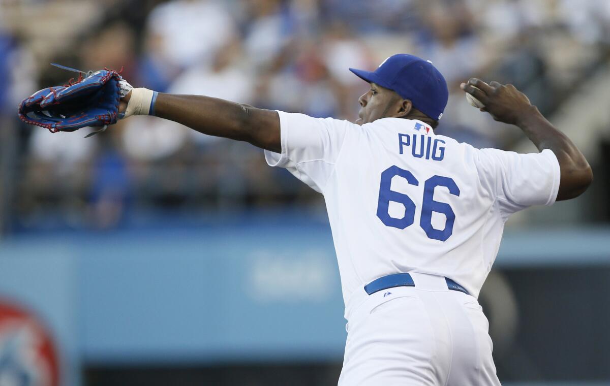 Dodgers right fielder Yasiel Puig fires a ball in after catching a fly ball in foul territory against the Brewers.