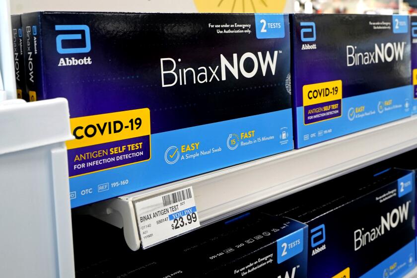 Boxes of BinaxNow home COVID-19 tests made by Abbott are shown for sale at a CVS store in Lakewood, Wash.